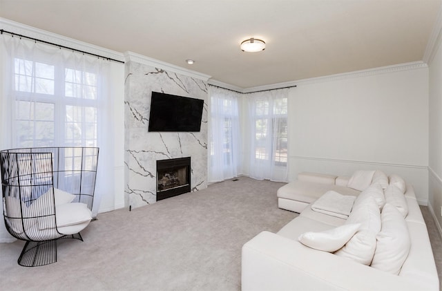 living room featuring a premium fireplace, ornamental molding, and carpet flooring