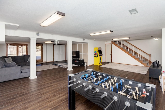 rec room with decorative columns, a textured ceiling, visible vents, and wood finished floors