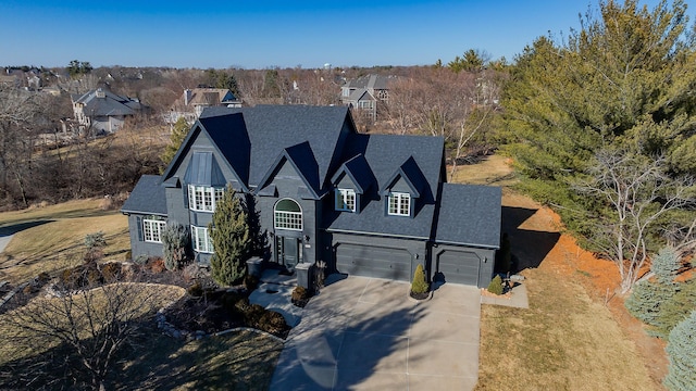 view of front of house featuring a chimney, a shingled roof, a garage, a front yard, and concrete driveway