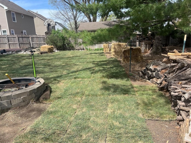 view of yard featuring an outdoor fire pit and fence