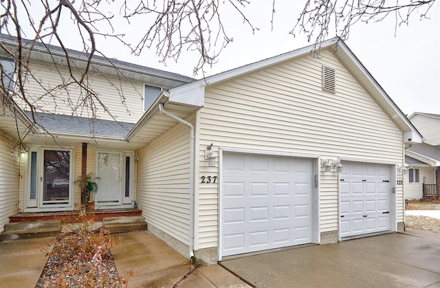 view of side of property featuring driveway and an attached garage