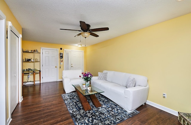 living area with baseboards, a textured ceiling, a ceiling fan, and wood finished floors