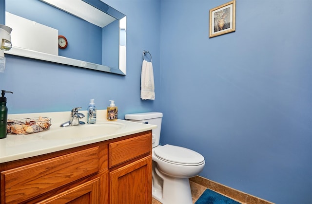 bathroom with baseboards, toilet, and vanity