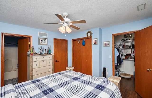 bedroom with wood finished floors, visible vents, and a textured ceiling