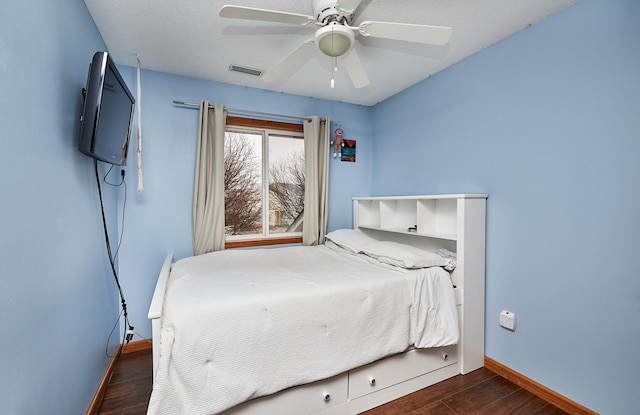 bedroom with visible vents, a ceiling fan, baseboards, and wood finished floors