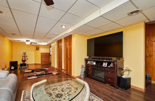 living area with dark wood finished floors, visible vents, and ceiling fan