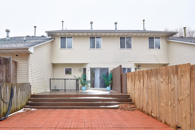 rear view of house with a patio and fence