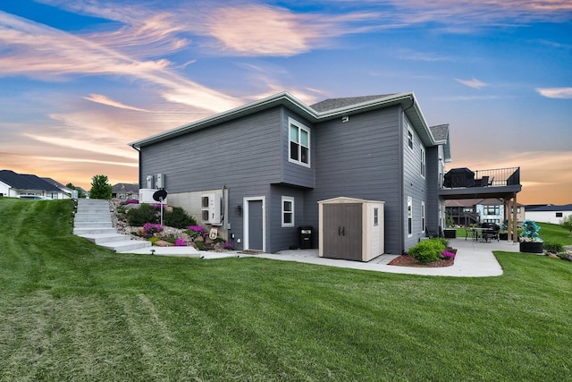 rear view of property with a patio, stairway, and a lawn