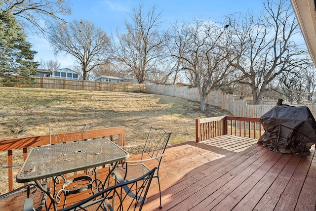 wooden terrace with outdoor dining space, a yard, and a fenced backyard