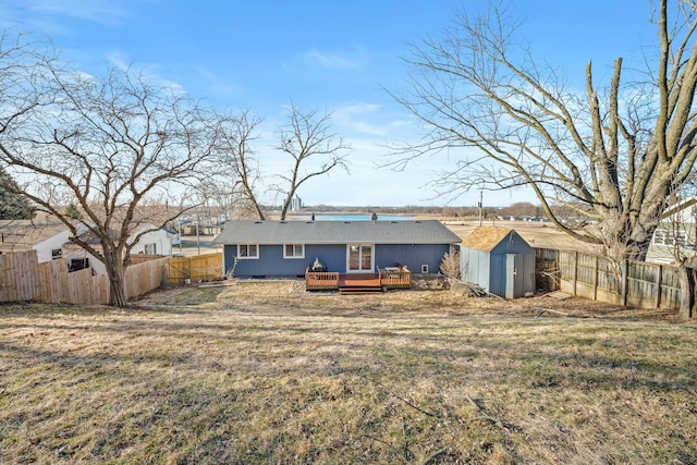 rear view of property with an outbuilding, a shed, a yard, a fenced backyard, and a deck