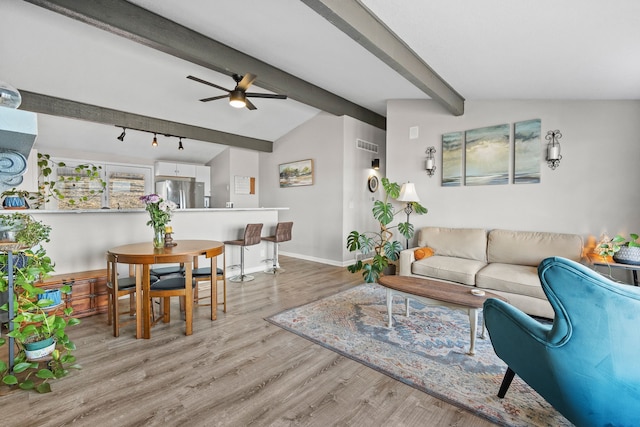 living room featuring visible vents, vaulted ceiling with beams, baseboards, light wood-style floors, and a ceiling fan