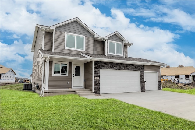 view of front facade featuring a front yard, driveway, central AC, a garage, and stone siding