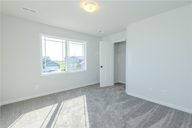 unfurnished bedroom with a closet, visible vents, baseboards, and carpet floors