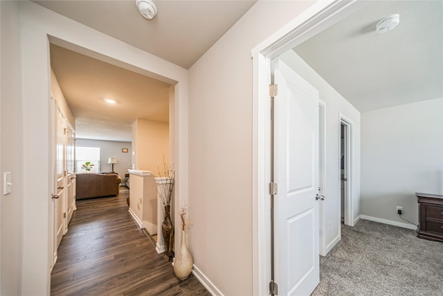 hall with baseboards and wood finished floors