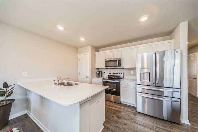 kitchen featuring dark wood-style floors, a sink, light countertops, appliances with stainless steel finishes, and white cabinetry