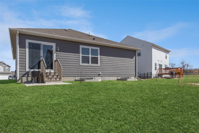 back of property with entry steps and a yard