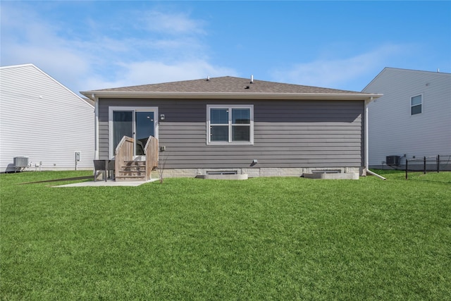 rear view of property with entry steps, a lawn, and central AC