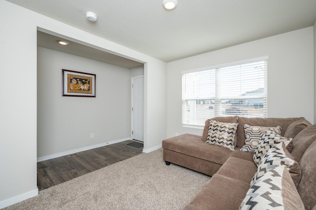 living room featuring baseboards and dark carpet