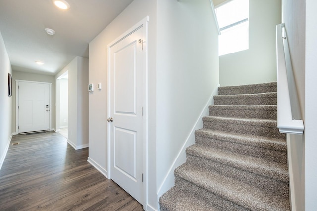 staircase with wood finished floors and baseboards