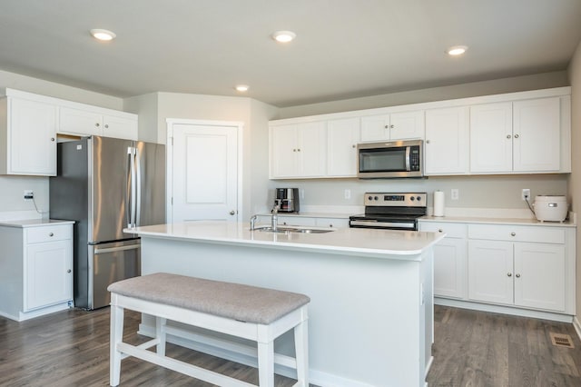 kitchen featuring a sink, dark wood finished floors, recessed lighting, stainless steel appliances, and white cabinets