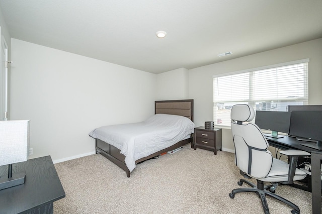 bedroom with baseboards, visible vents, and light carpet