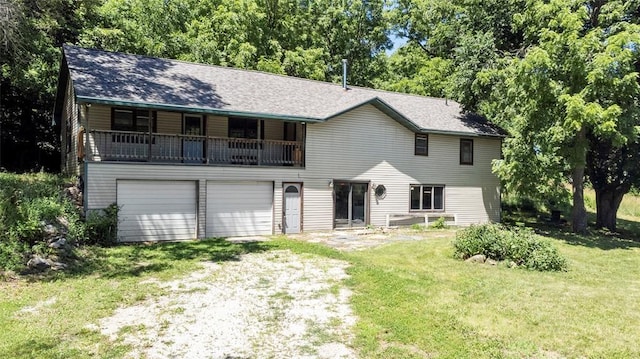 view of front of property with a front yard, a garage, dirt driveway, and a shingled roof