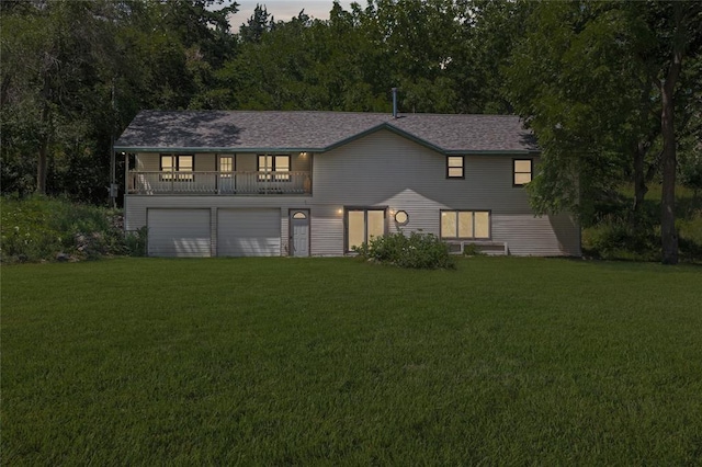 view of front of house featuring a garage, a balcony, and a lawn