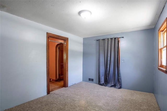 unfurnished room with carpet flooring and visible vents