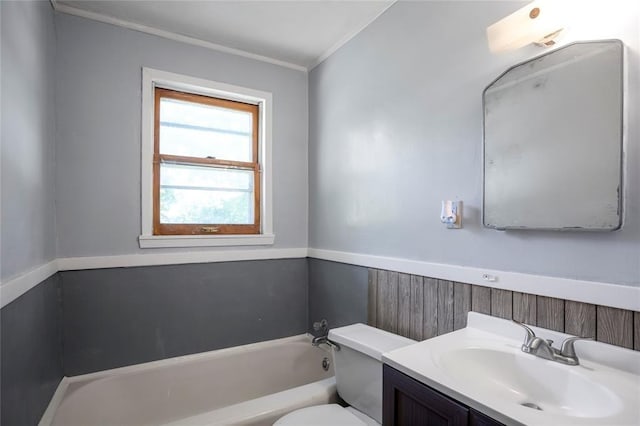 bathroom featuring a tub, a wainscoted wall, toilet, and vanity