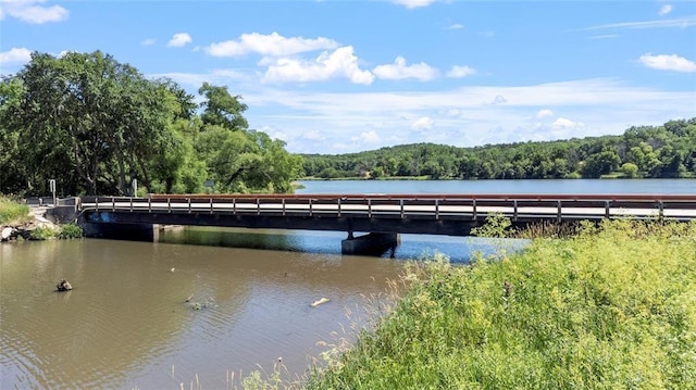 view of dock featuring a forest view and a water view