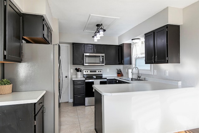 kitchen featuring a sink, appliances with stainless steel finishes, a peninsula, light countertops, and light tile patterned floors