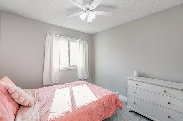 carpeted bedroom featuring baseboards, a textured ceiling, and ceiling fan