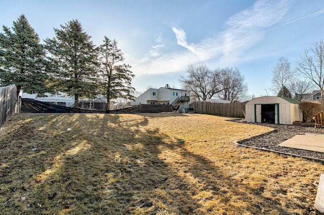 view of yard featuring a storage unit, a fenced backyard, and an outdoor structure