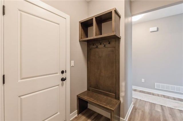 mudroom with wood finished floors, visible vents, and baseboards