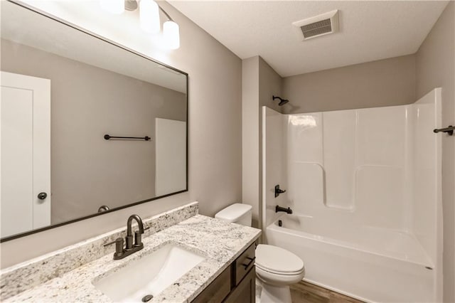 full bath featuring visible vents, toilet, a textured ceiling, vanity, and shower / bathtub combination