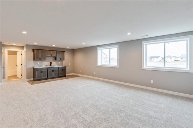 unfurnished living room with light carpet, recessed lighting, and baseboards