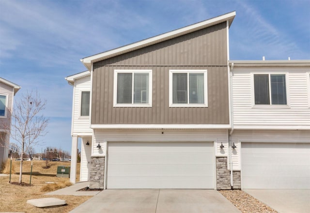 view of front of house with stone siding, concrete driveway, and a garage