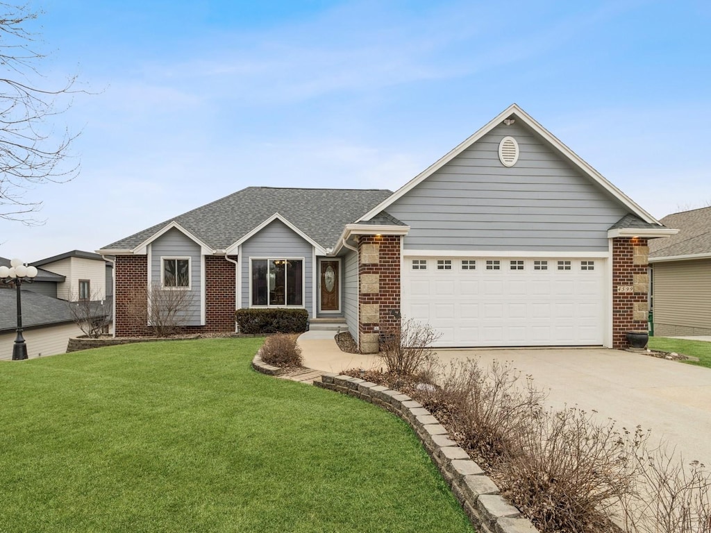 ranch-style house with brick siding, concrete driveway, roof with shingles, a front yard, and a garage