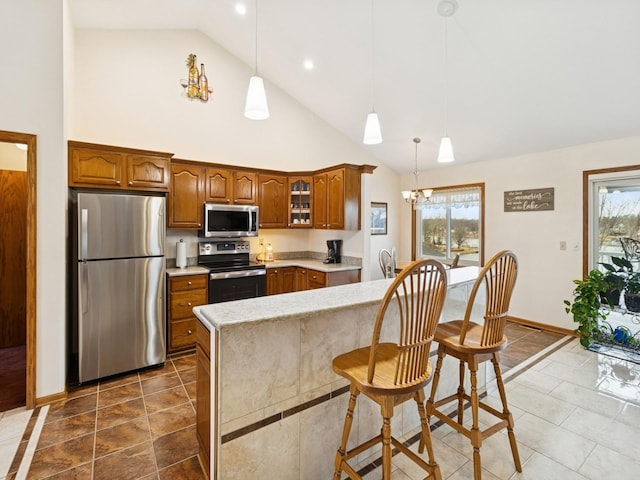 kitchen featuring stainless steel appliances, plenty of natural light, brown cabinets, and light countertops