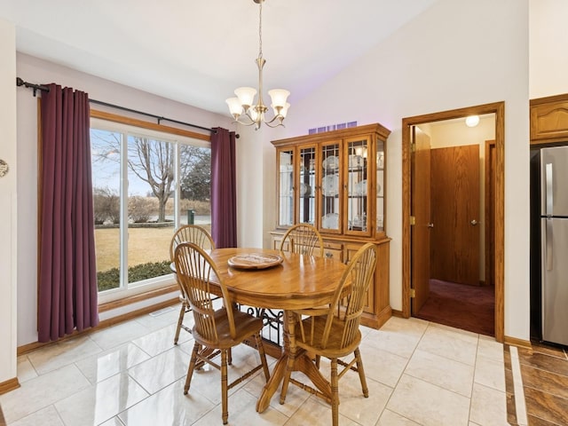 dining room featuring lofted ceiling, a notable chandelier, light tile patterned floors, and baseboards