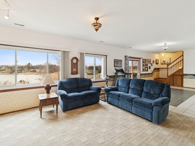 tiled living area featuring visible vents, baseboards, stairs, and wallpapered walls