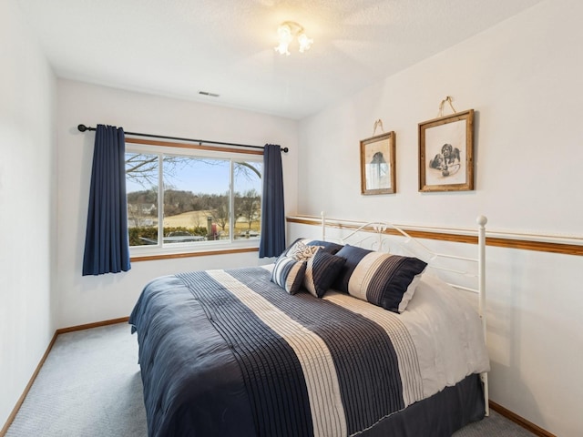 bedroom featuring visible vents, baseboards, and carpet