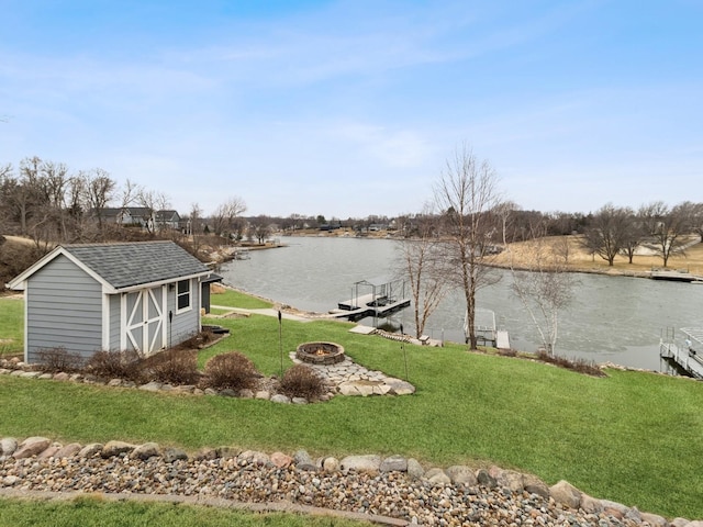 water view with a fire pit and a dock