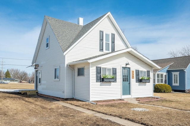 view of front of house featuring a front lawn and roof with shingles