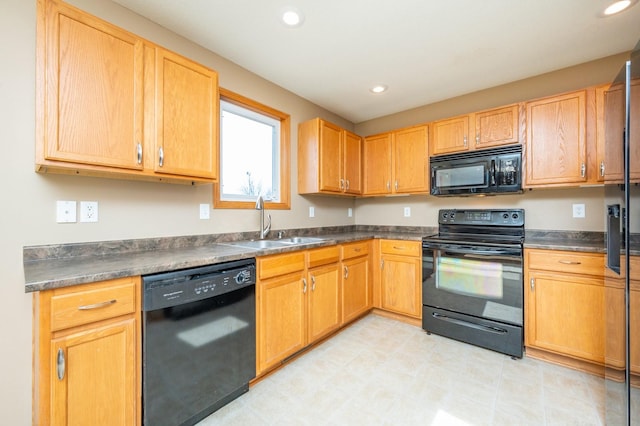 kitchen with a sink, dark countertops, and black appliances