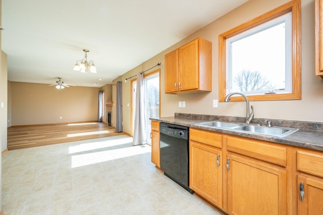 kitchen with a sink, black dishwasher, dark countertops, open floor plan, and hanging light fixtures