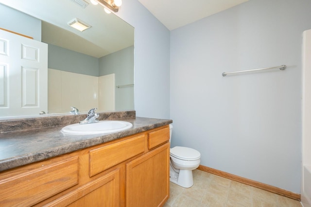 bathroom with toilet, vanity, and baseboards