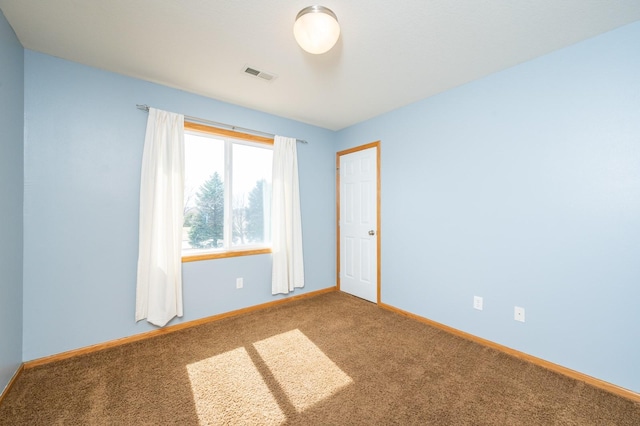 carpeted spare room with baseboards and visible vents