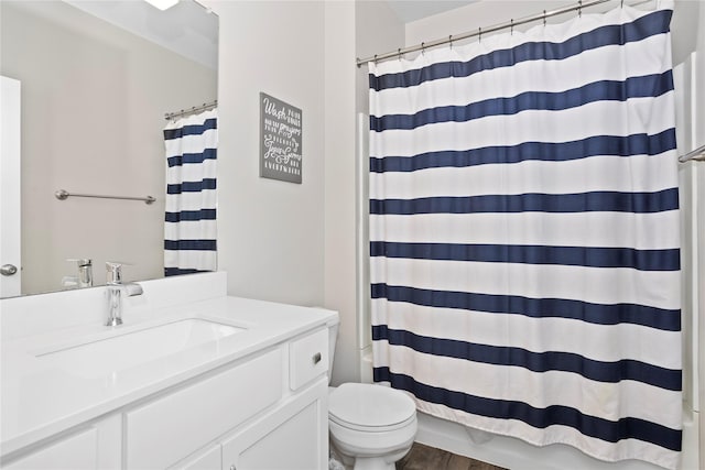 bathroom featuring toilet, curtained shower, and wood finished floors