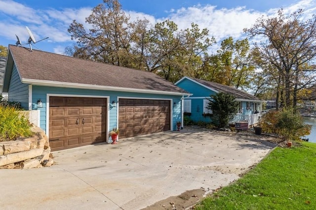 view of front of property with a garage and roof with shingles